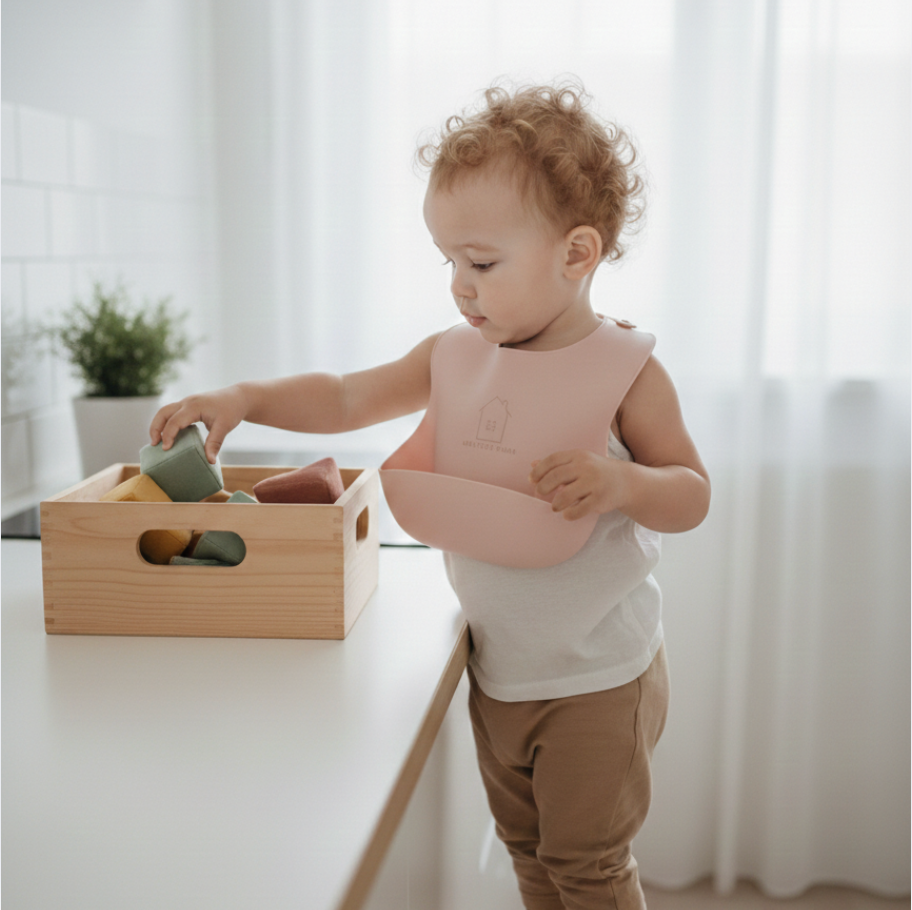 Mažylis su silikoniniu seilinuku mokosi savarankiškai valgyti namuose