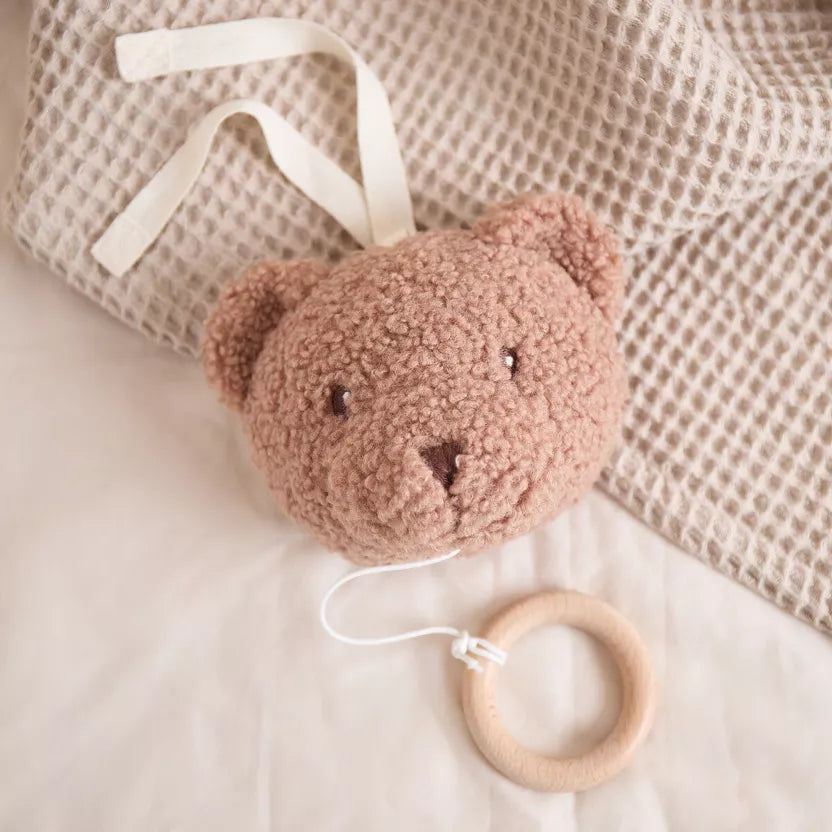 Grojantis meškiukas rudos spalvos, pakabinamas prie vaiko lovytės